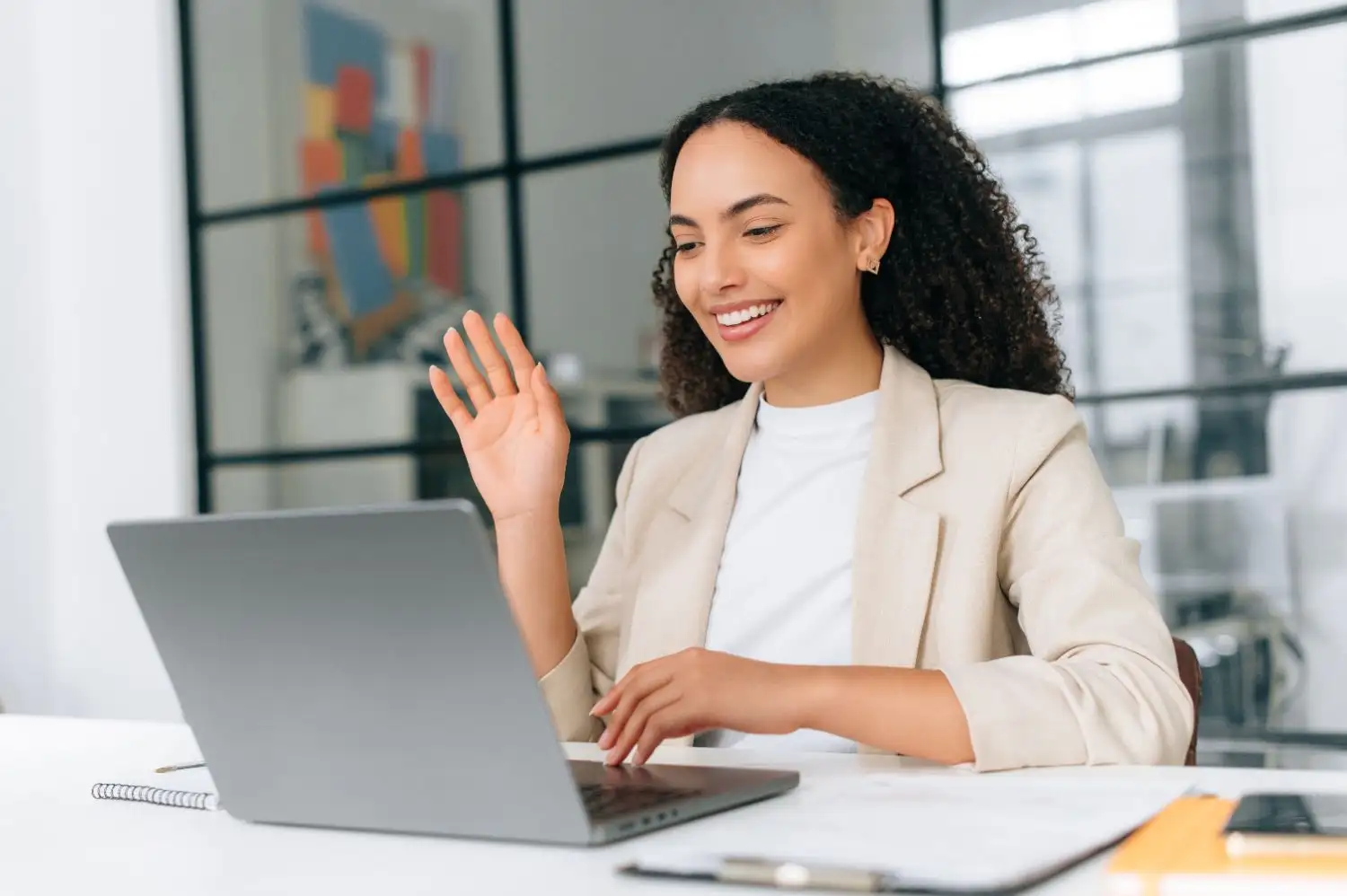 Woman waving while on a online call