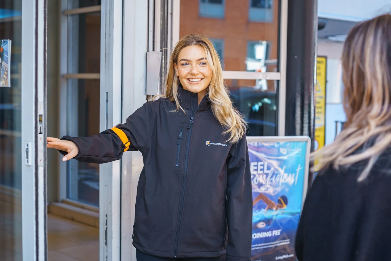 Woman security guard opening door